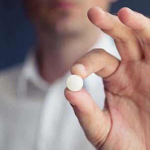 Medical news - man holding acetaminophen tablet