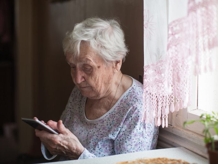house fires - Senior woman using her smartphone