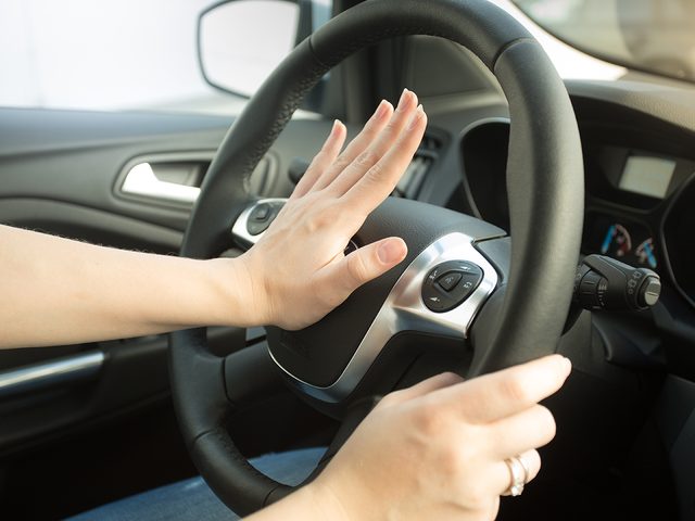 How to reduce car insurance - woman honking car horn