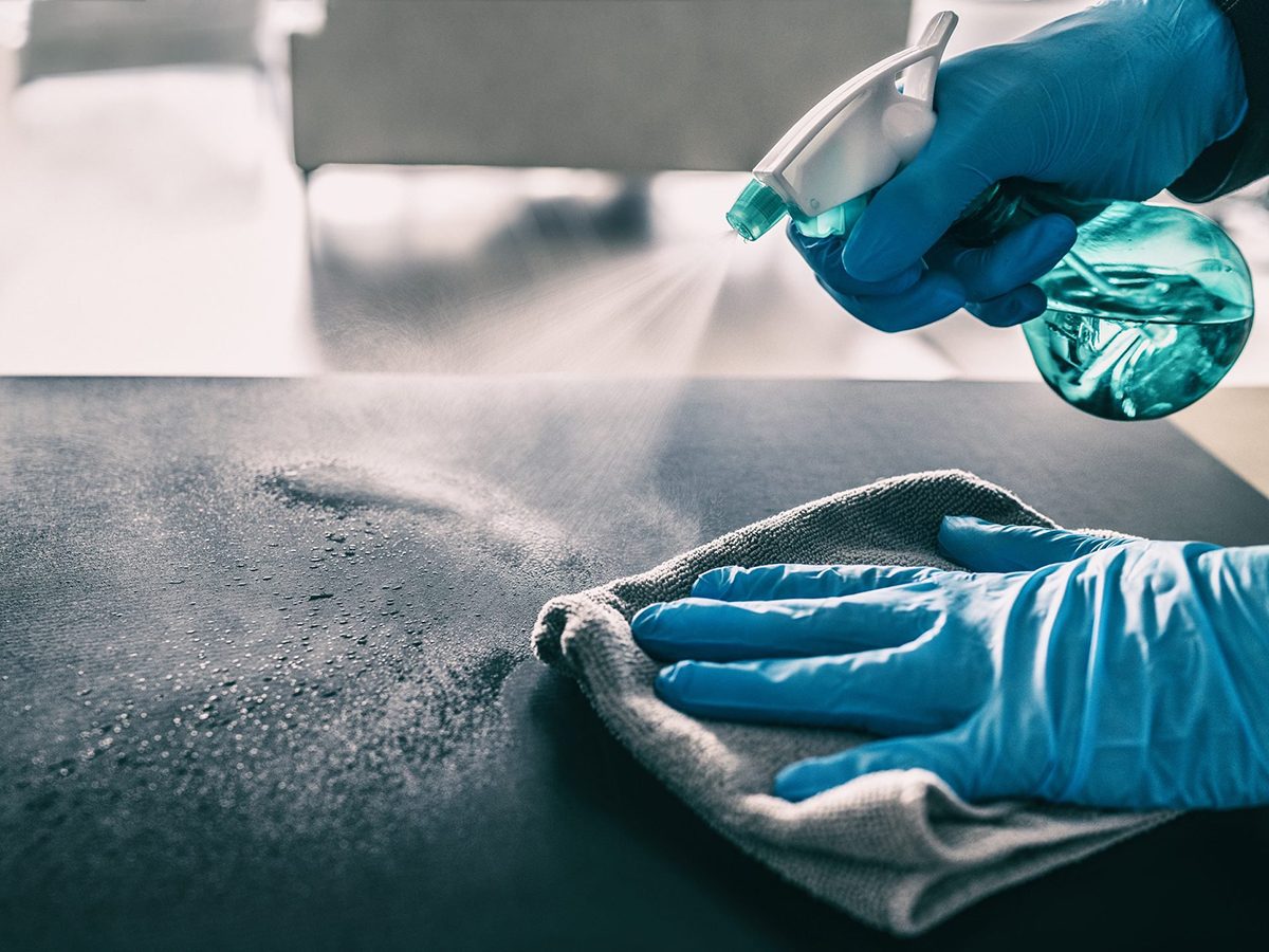 Mistakes you're making with disinfection - Surface sanitizing against COVID-19 outbreak. Home cleaning spraying antibacterial spray bottle disinfecting against coronavirus wearing nitrile gloves. Sanitize hospital surfaces prevention.