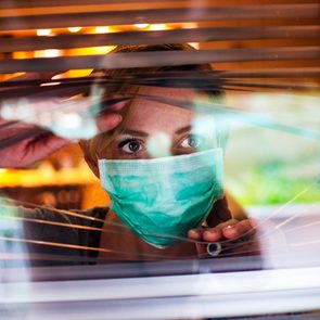 Signs You May Have High Functioning Anxiety - woman in mask looking out window