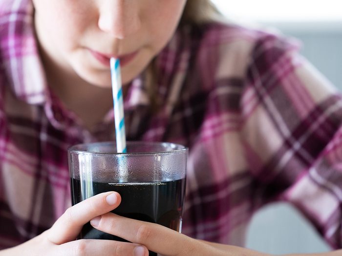 worst foods for brain - Close Up Of Girl Drinking Sugary Fizzy Soda From Glass With Straw