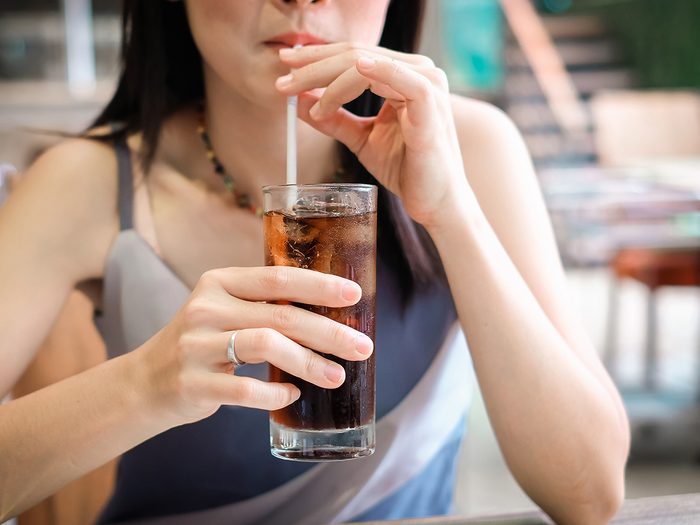 closeup woman drinking ice cola soda in the glass.food and beverage concept