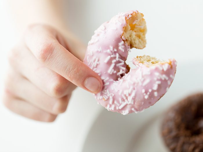 Worst foods for your heart - woman holding doughnut