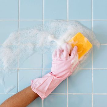 How to clean your bathroom in five minutes - Hand in pink glove with sponge washing