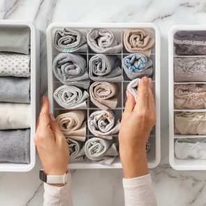 Clever home organizing hacks - woman separating clothes in storage