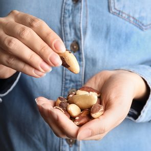 Woman holding delicious Brazil nuts, closeup view