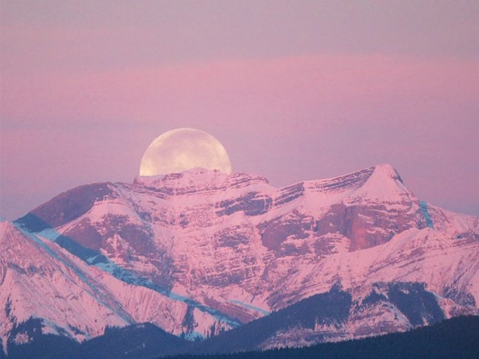 Photos of the moon - pink sky moon rising over mountains