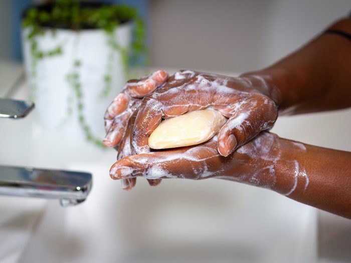 woman washing hands with soap in sink