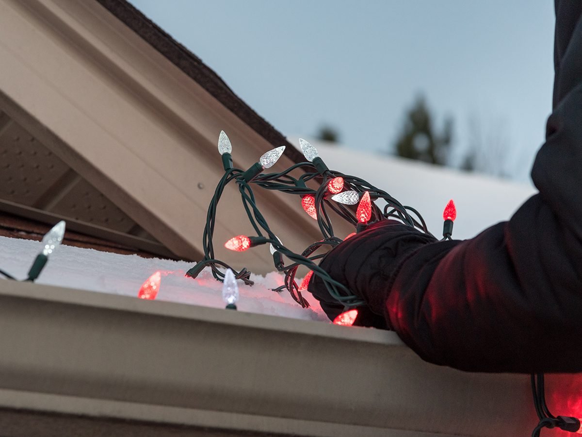 Guide to Christmas lights - Man putting lights on roof