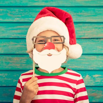 Funny Christmas jokes for kids - kid dressing up as Santa