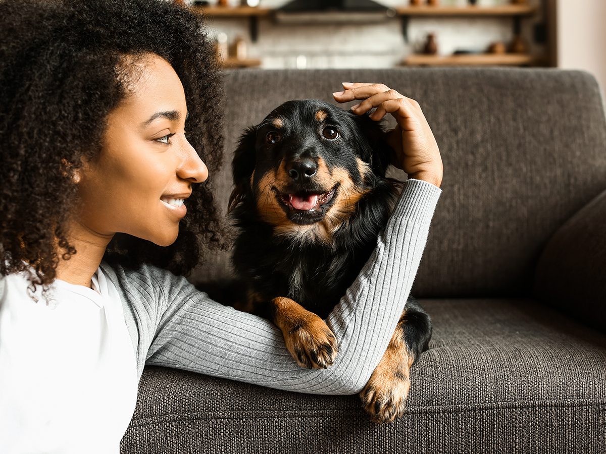 Most popular dog names in Canada - Woman with dog sitting on sofa