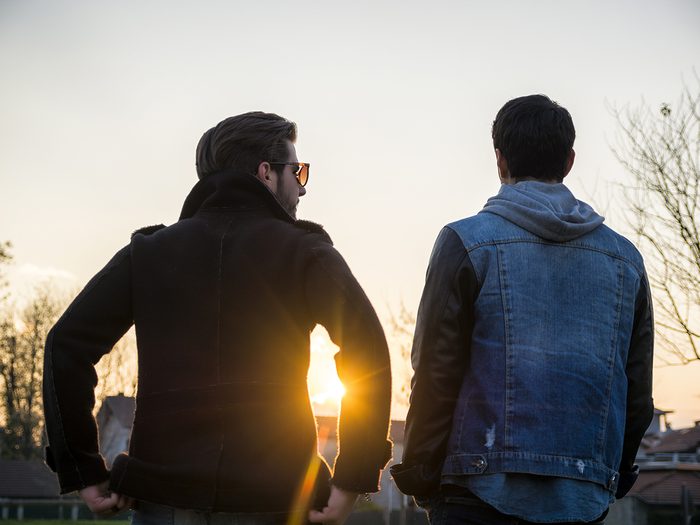 Two young men walking at sunset