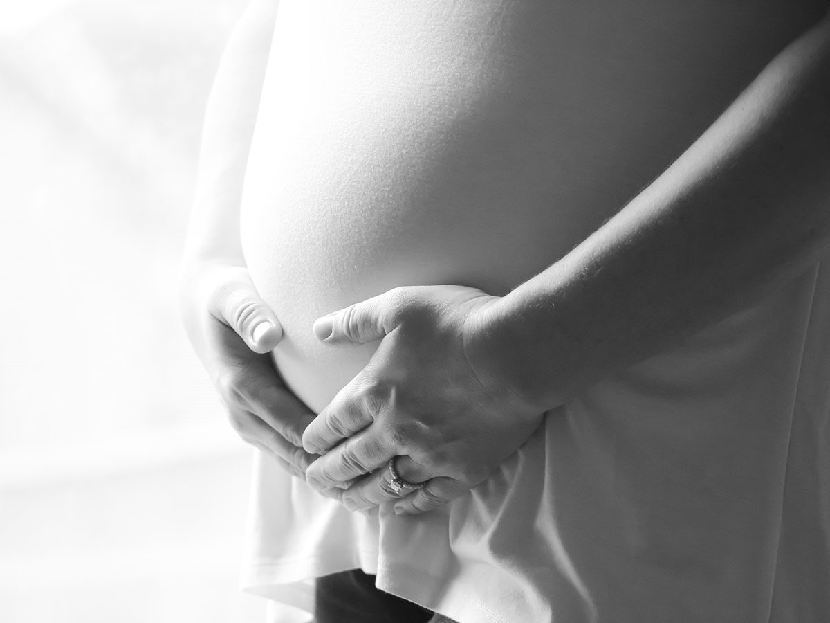 A black and white photo of a pregnant stomach