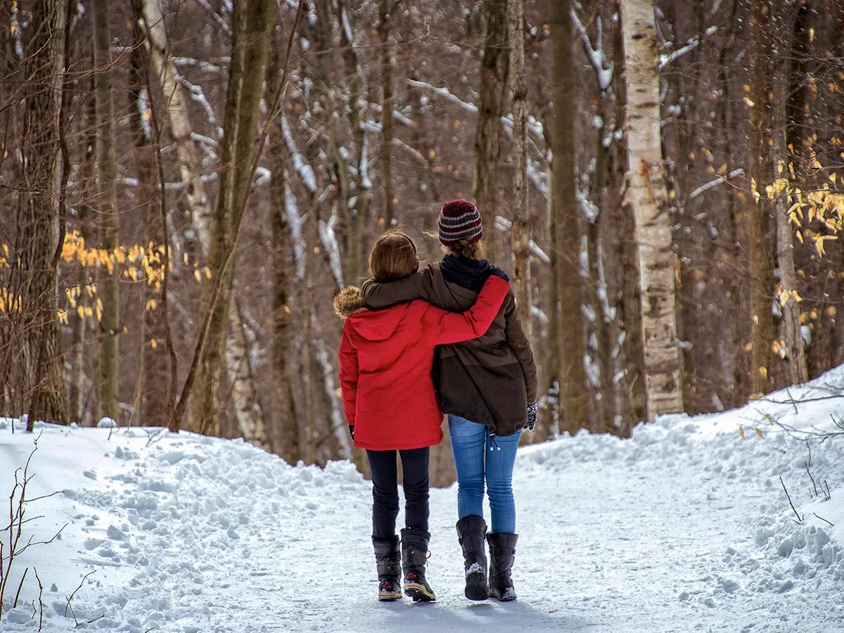 Two girls walking in a snowy woods