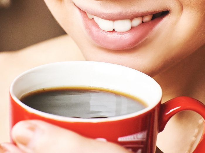 Coffee stains teeth - smiling woman drinking coffee