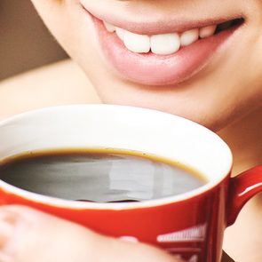 Coffee stains teeth - smiling woman drinking coffee