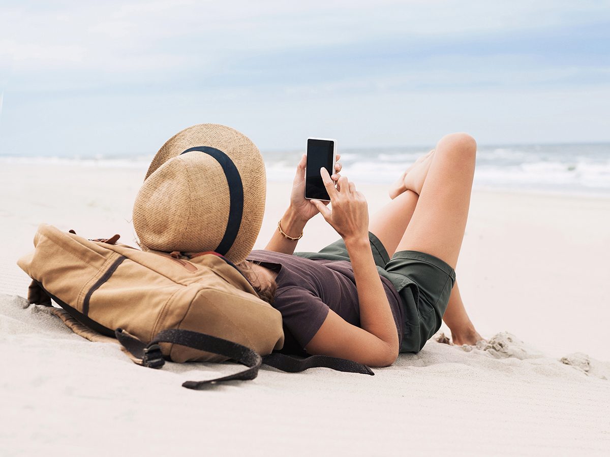 Creepy things your phone knows about you - woman on beach with phone
