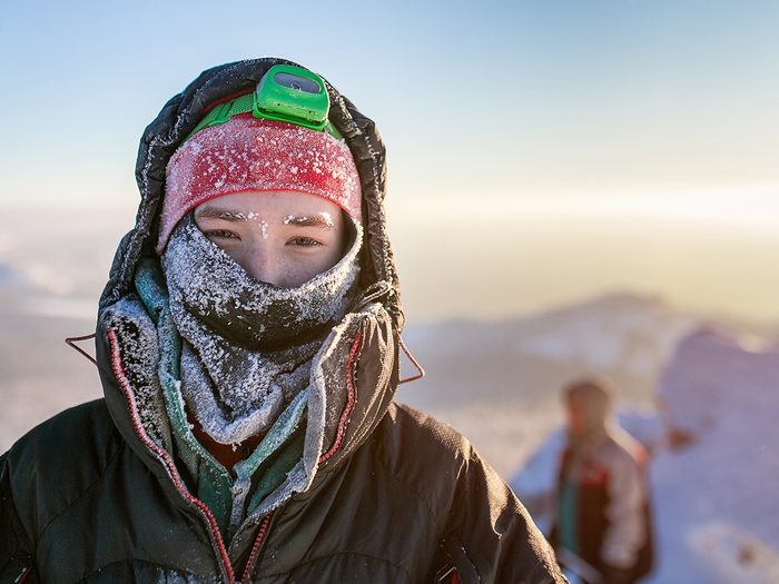 how your body deals with freezing weather - Frost Portrait of a hiker Climber. Wrapped in hat and scarf