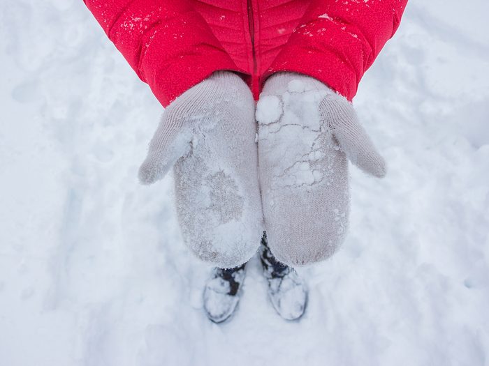 how your body deals with freezing weather - Ivory woman gloves in snow with red coat