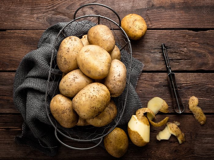 Potatoes in basket being peeled