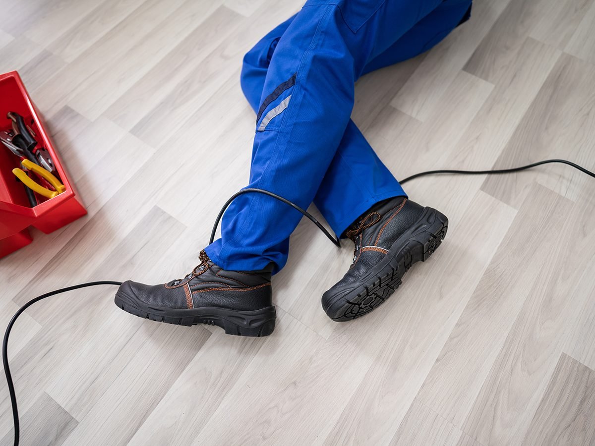 Low Section Of Male Electrician Wrapped In Wire Fallen On Floor