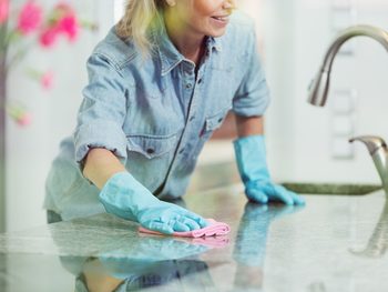 Spring cleaning checklist - woman wiping kitchen counter