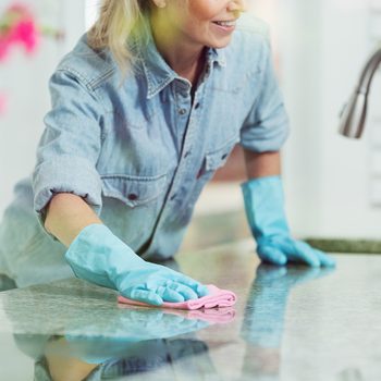 Spring cleaning checklist - woman wiping kitchen counter