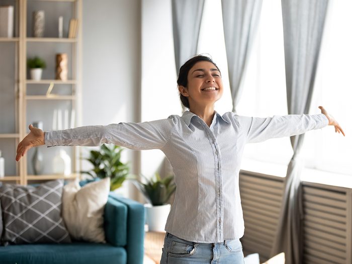 Healthy home checklist - happy woman in living room
