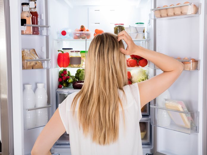 How To Organize Your Fridge - woman standing in front of open fridge