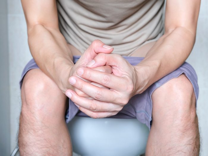 Parkinson's Disease symptoms - constipated man sitting on toilet