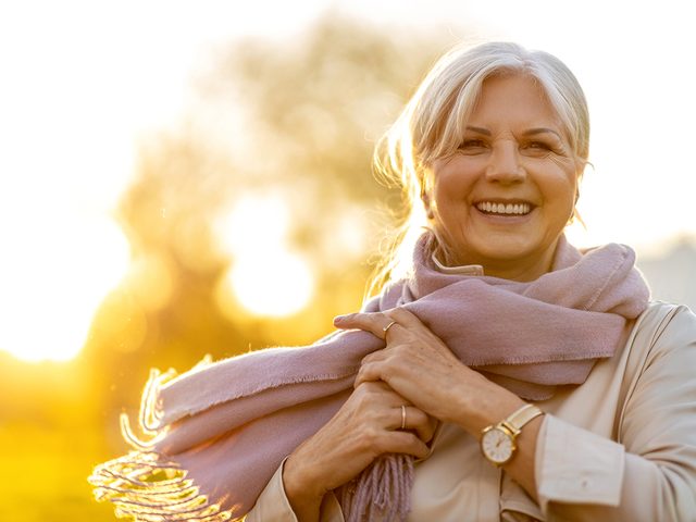 Signs you need more calcium - mature woman enjoying sunshine