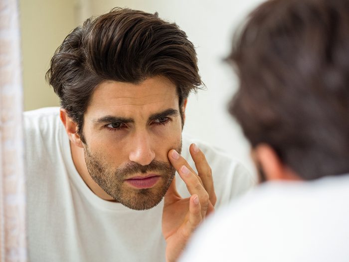 Silent signs of stress - man checking face in mirror