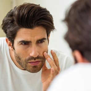 Silent signs of stress - man checking face in mirror