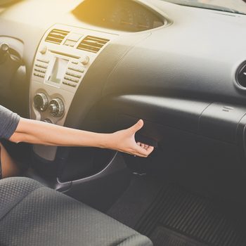 Woman reaching into car glove compartment