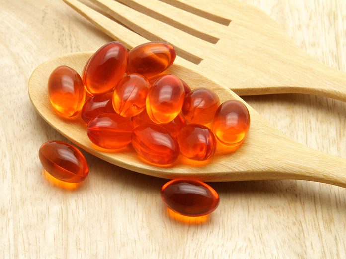 Vitamin, Coenzyme Q10 on the wooden spoon for anti-aging.