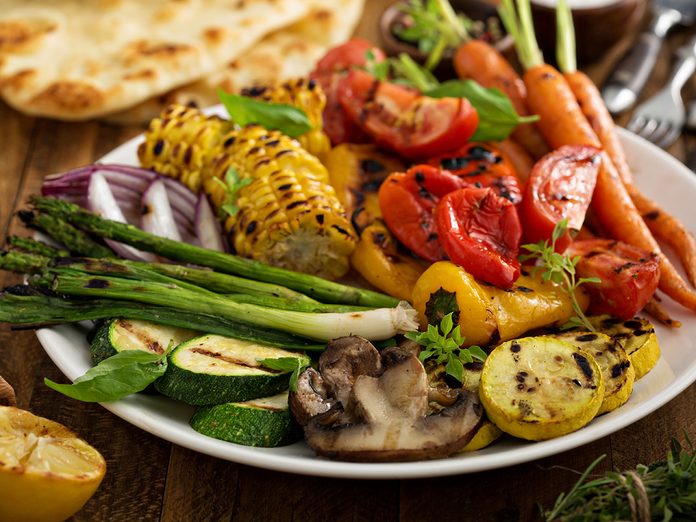 Grilled vegetables and chicken on wooden table overhead shot