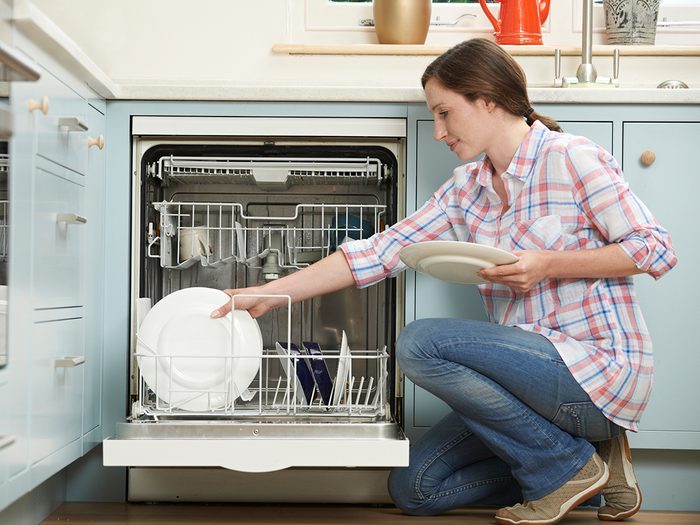 Woman unloading dishwasher