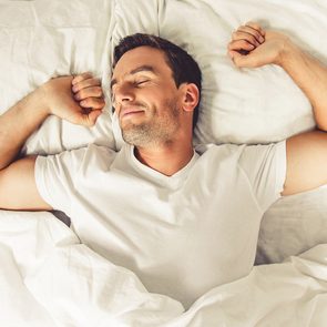 Best vitamins for sleep - happy sleeping man in bed