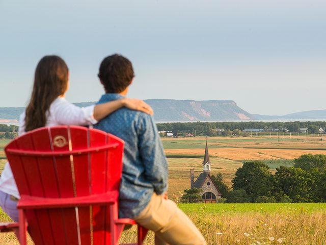 Historical Places Canada - Visitors with red chairs at the Landscape of Grand-Pr View Park. A UNESCO World Heritage Site. Grand-Pre National Historic Site.
