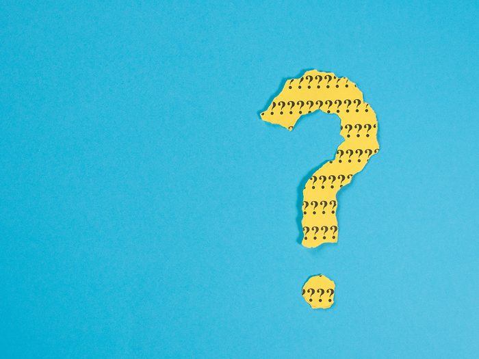 question mark symbol from a teared yellow paper on a blue background with copy space. Concept of FAQ, Q and A, Questions and riddle