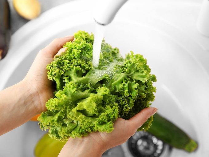 How to wash lettuce - Female hands washing fresh vegetables in kitchen sink