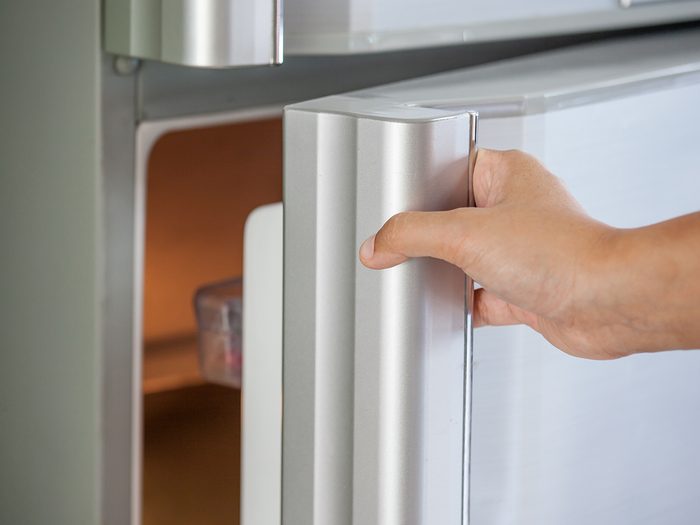Energy saving tips - woman reaching into fridge