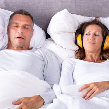 How to stop snoring - woman wearing headphones in bed