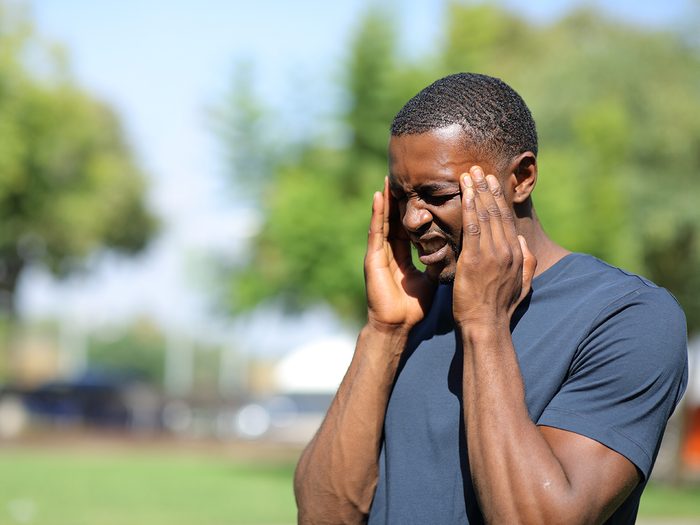 Signs of heat stroke - man with headache outdoors