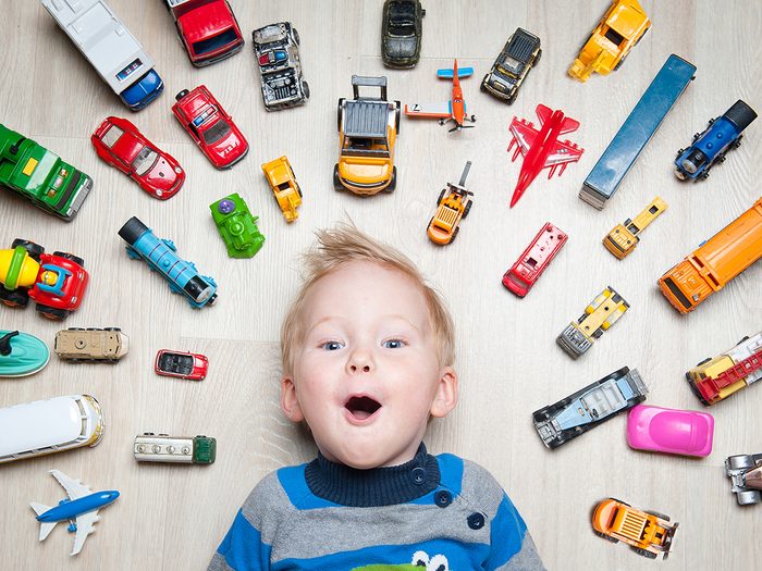 Childhood toys - child surrounded by Hot Wheels toy cars