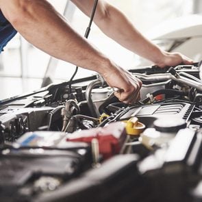 DIY car maintenance and repair - man working under hood