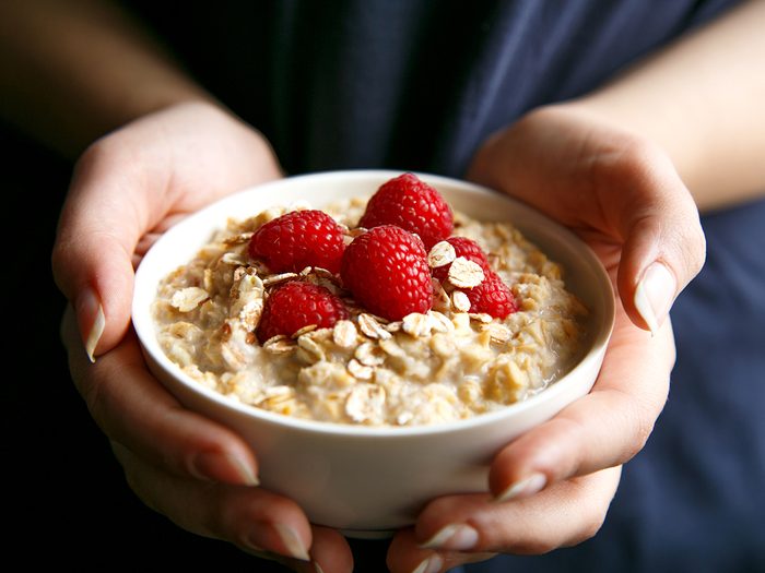 Foods that make you poop - woman holding bowl of oatmeal