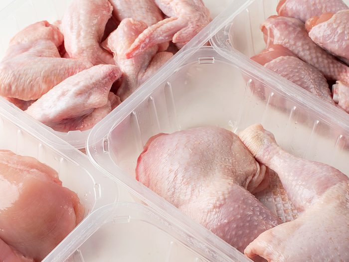 Different types of raw chicken meat in plastic boxes