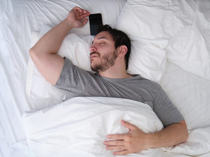Man sleeping with phone in bed